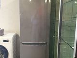 a silver refrigerator and a washing machine in a room