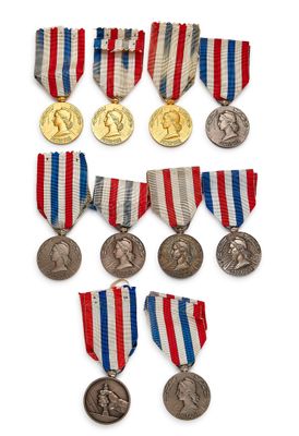 plusieurs médailles et médailles sont exposées sur une surface blanche