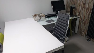 un bureau avec un ordinateur et une chaise dans une pièce