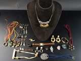 une table noire sur laquelle sont posés un chapeau marron et de nombreux bijoux