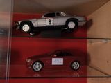 trois petites voitures exposées dans une vitrine