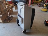 a white refrigerator sitting on top of a cart in a garage