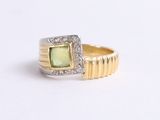 an image of a ring with a green stone surrounded by diamonds