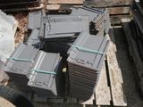 a pile of gray boxes sitting on top of a wooden pallet