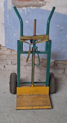 a green hand truck with a wooden handle on it
