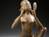 une image représentant une statue en bronze d'une femme assise par terre