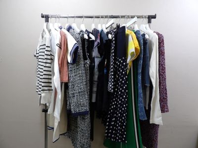 a lot of clothes hanging on a rack in a room