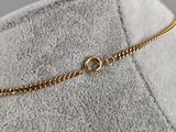 a close up of a gold chain bracelet on a chair