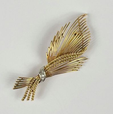 une broche en or ornée d'un diamant au centre