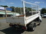 a white truck with a cage on the back parked in a parking lot
