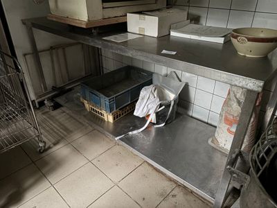 une étagère métallique au milieu d'une cuisine, sur laquelle est posé un micro-ondes