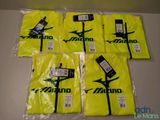 six t-shirts Mizuno dans des sacs en plastique posés sur une table