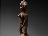 an image of a statue of a man standing on top of a wooden base