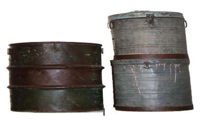two old metal containers sitting side by side on a white surface