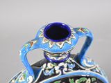 a blue and black vase with a floral design on it