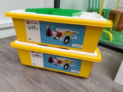 deux boîtes jaunes ornées de Lego, posées par terre