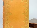 an old book sitting next to a small box on a white surface