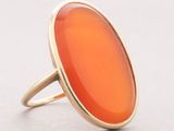 a close up of a ring with an orange stone in it
