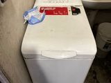 une machine à laver et des toilettes dans une petite pièce