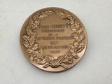 an old medal with a wreath on it sitting on a table