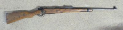 a close up of a rifle laying on the ground on a floor