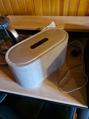 une enceinte blanche posée sur une table en bois