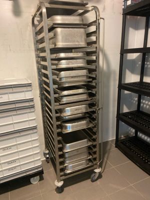 Plusieurs plateaux de nourriture sont empilés sur un chariot dans une cuisine