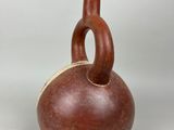 two brown vases sitting on top of each other on a white surface