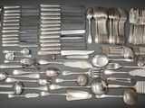 a lot of silver spoons and forks on the table