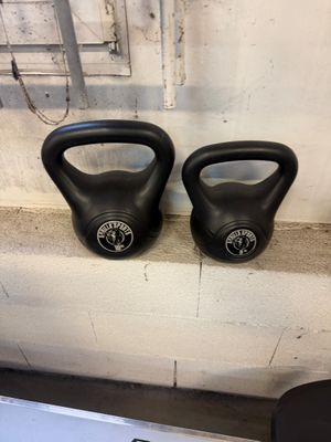 two kettlebells sitting on a shelf in a gym