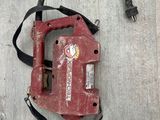 a red tool that is laying on a wooden floor
