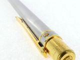 an image of a gold and silver pen on a white surface