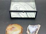 three pieces of agite are sitting on a table next to a glass box