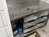 a stainless steel counter with plastic bins on it