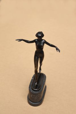 une statue en bronze représentant une femme debout sur une planche de surf