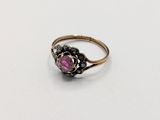 a close up of a pink stone ring on a white surface