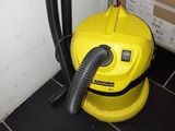 un aspirateur jaune posé par terre à côté d'un carton