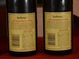 three bottles of wine are lined up on a wooden table