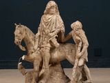 a statue of a man riding a horse with two children on it
