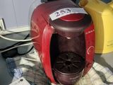 a red coffee maker sitting on a counter next to a box of milk