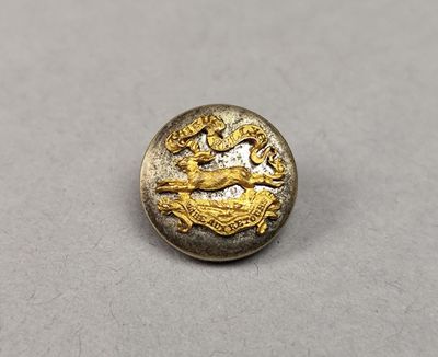 un gros plan d'un bouton doré orné d'un cheval