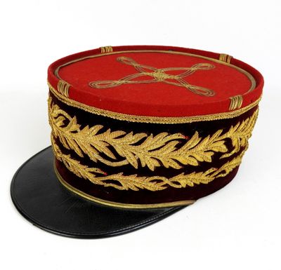 un chapeau rouge et noir orné d'un motif doré