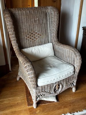 une chaise en osier dans un coin de la pièce