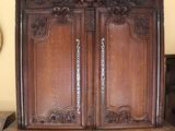 a large wooden cabinet with a mirror on the wall