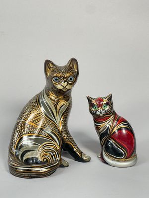 deux figurines de chats assis l'un à côté de l'autre