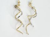 une paire de boucles d'oreilles en or et en argent sur fond blanc