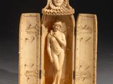 figurine en ivoire sculpté représentant une femme tenant un bébé dans une boîte en bois ouverte