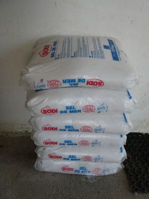 a pile of bags of black seed next to a pile of black seed