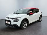 Une Citroën blanche est garée dans une pièce blanche