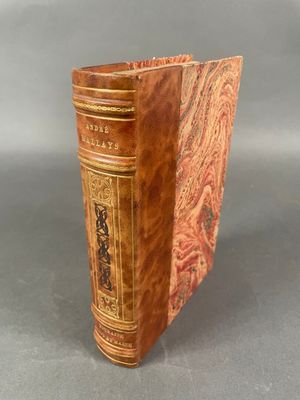 un vieux livre à la couverture décorative posé sur une table